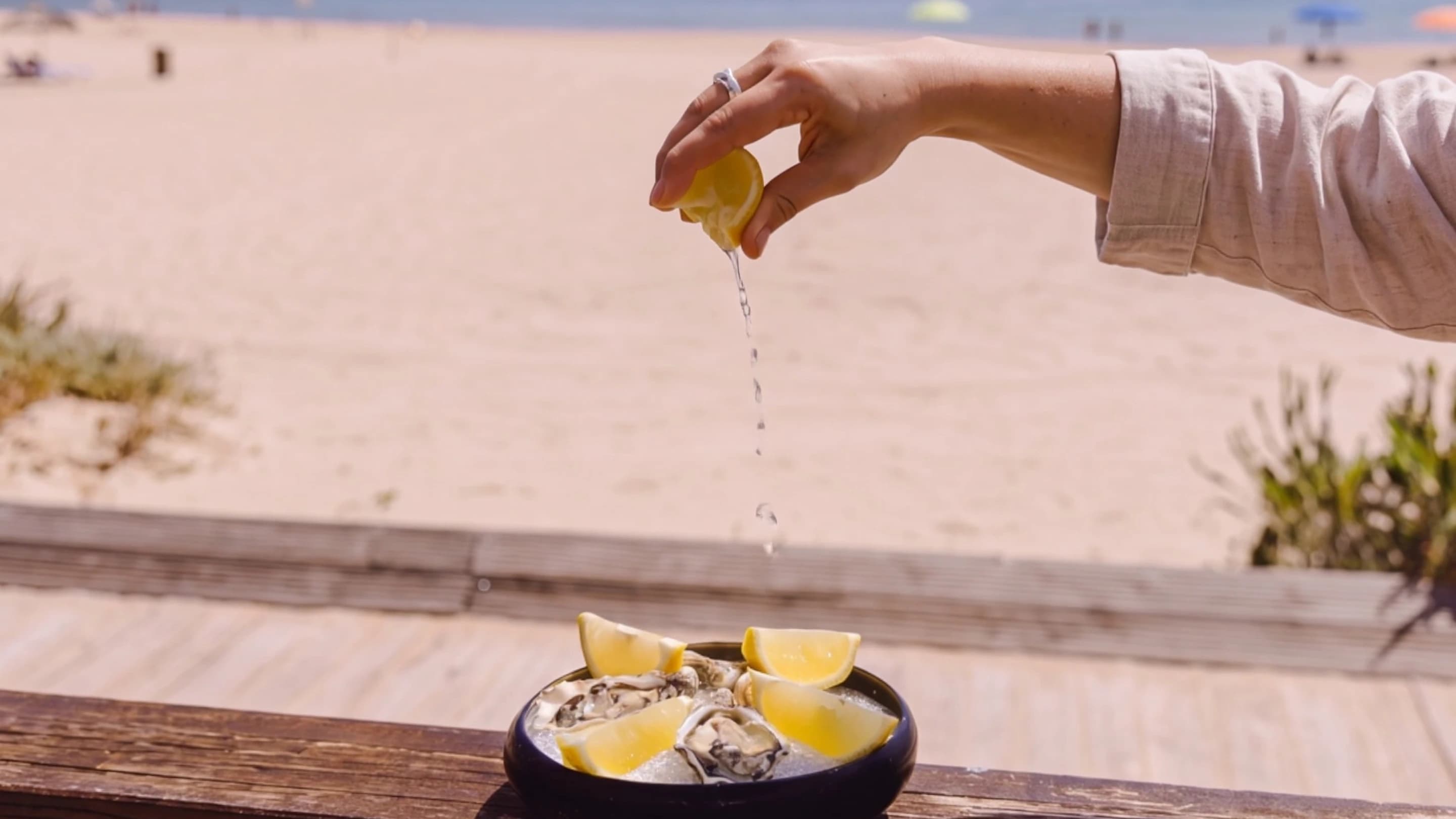 A lemon squeezed over oysters on the Portofino terrace above Praia do Ouro